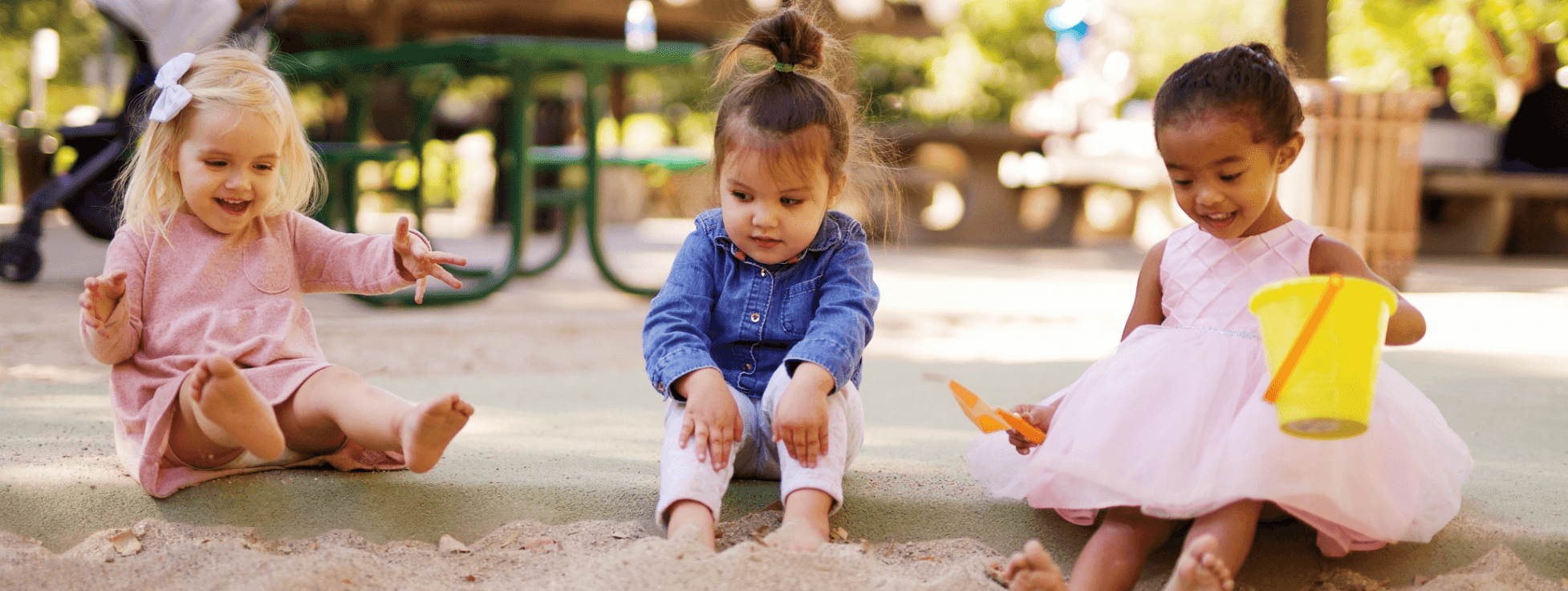 drei Kinder spielen im Sandkasten